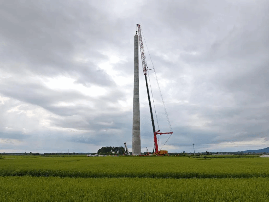 山西建投装置集团承建的黑龙江省通河200MW风储一体化项目首台风机混塔段吊装完成